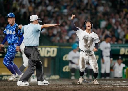 青藍泰斗―佐賀北　タイブレークの１０回裏、山下のスクイズで生還し、喜ぶ佐賀北の三走塚原。左は青藍泰斗・永井＝甲子園