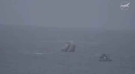 米カリフォルニア州沖の海面に着水した、大西卓哉飛行士ら搭乗の宇宙船クルードラゴン（左）＝９日（ＮＡＳＡの中継から・共同）