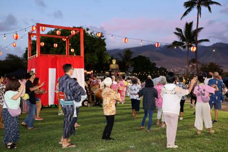 ９日、米ハワイ州マウイ島ラハイナで、盆踊りに参加する人たち（共同）
