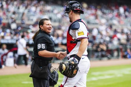 米大リーグの公式戦で捕手と握手するパウォルさん＝１０日、アトランタ（ゲッティ＝共同）