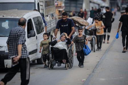 イスラエル軍による攻撃後、安全な場所へ避難するパレスチナ人ら＝１２日、ガザ北部ガザ市（ゲッティ＝共同）