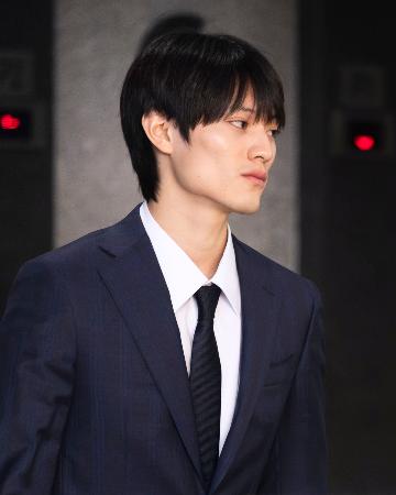 有罪判決を受け、裁判所を後にする上村謙信被告＝１３日、香港（共同）