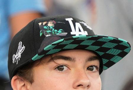 ドジャースが配布した「鬼滅の刃」とコラボレーションした帽子をかぶる観客＝ロサンゼルス（共同）