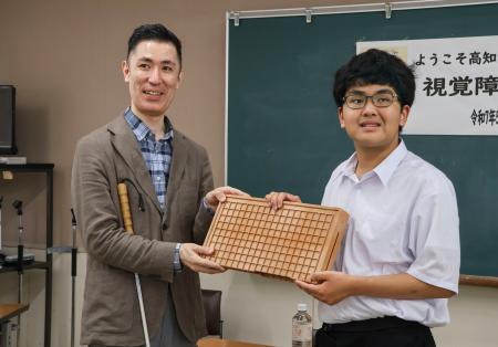 盲学校などに「アイゴ」の寄贈を行っている柿島光晴さん（左）＝５月、高知市
