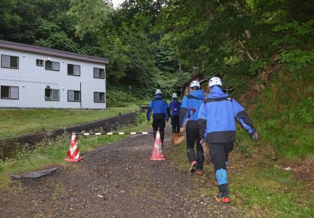 １５日午前、閉鎖された羅臼岳の登山口から入山する捜索隊＝北海道斜里町