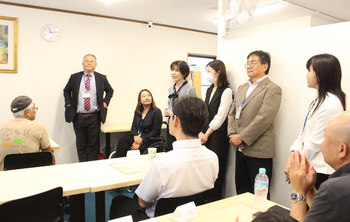 開所式であいさつするスタッフ