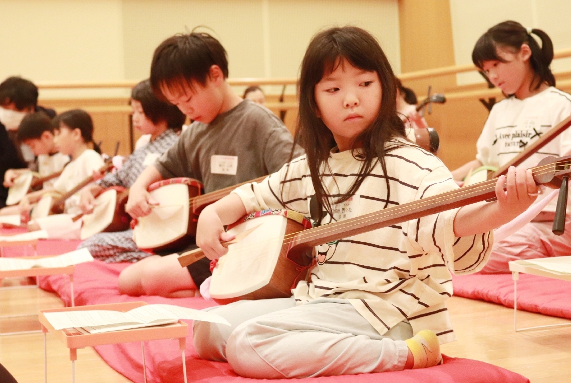 長唄の体験イベントで、三味線の演奏に挑戦する子どもたち＝１７日、大分市