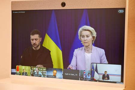 フランスのマクロン大統領とのオンライン会見に臨むウクライナのゼレンスキー大統領（左）とＥＵのフォンデアライエン欧州委員長を映すスクリーン＝１７日（ＡＰ＝共同）