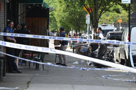 １７日、米ニューヨーク市南部ブルックリンの銃撃事件現場で活動する捜査員ら（ゲッティ＝共同）