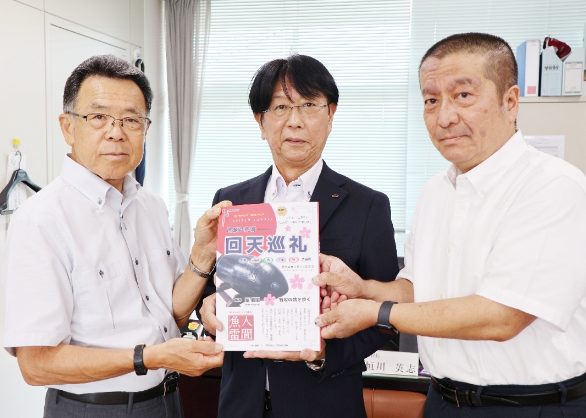 恒川英志教育長（中央）に人間魚雷、回天の書籍を贈る大神回天会のメンバー＝日出町教委