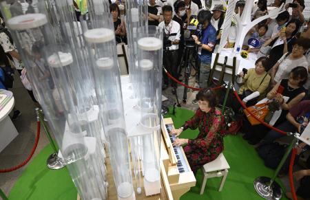 お披露目されたプラスチック製パイプオルガンを演奏するオルガニストの住山玖爾子さん＝１９日午後、大阪市此花区の夢洲