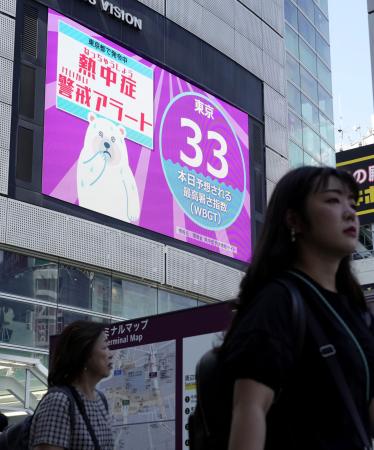 街頭モニターに表示された「熱中症警戒アラート」と暑さ指数＝７月、東京・新宿
