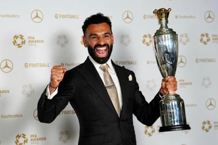イングランド・サッカーのプロ選手協会の男子最優秀選手に選出され、トロフィーを手に笑顔のモハメド・サラー＝１９日、マンチェスター（ＰＡ提供・ＡＰ＝共同）