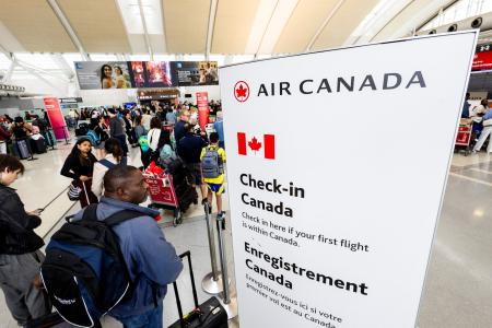 １９日、カナダ航空最大手エア・カナダのストライキが終結し、空港で搭乗手続きの列に並ぶ旅客＝カナダ・オンタリオ州（ロイター＝共同）