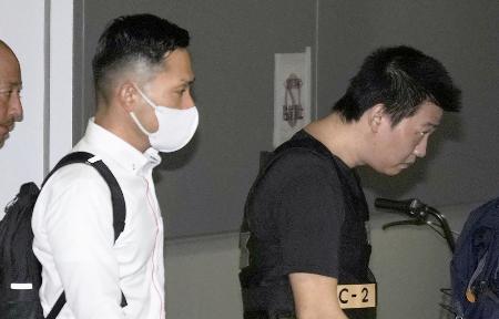 カンボジアから移送され、中部空港に到着した容疑者（右）＝２０日