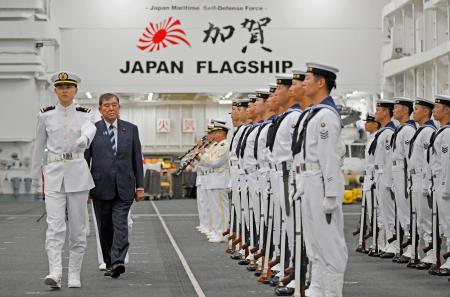 海上自衛隊の護衛艦「かが」で、儀仗（ぎじょう）隊を巡閲する石破首相（左から２人目）＝２３日午前、神奈川県横須賀市の海自横須賀基地（代表撮影）