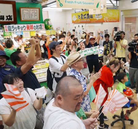 沖縄尚学高の優勝が決まり、那覇市の第一牧志公設市場で喜ぶ人たち＝２３日午後