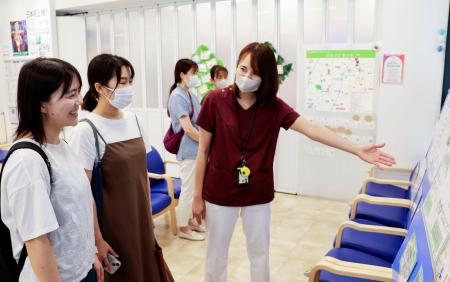 展示内容を紹介する筑波大付属病院の医師の西田恵子さん（手前右）＝６月、茨城県つくば市