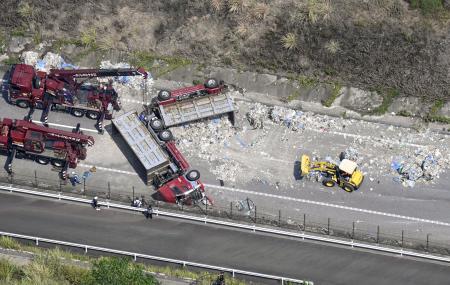 新東名高速道路下り線でトレーラーが横転し、積み荷の鉄くずなどが大量に散乱した事故現場＝２６日午前１１時１３分、愛知県岡崎市（共同通信社ヘリから）