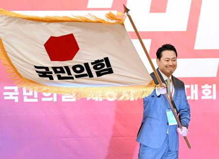 韓国の保守系最大野党「国民の力」の新代表に選出され、党の旗を掲げる張東赫国会議員＝２６日、ソウル（共同）