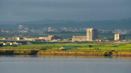「中朝鴨緑江大橋」の北朝鮮側で進む税関施設とみられる建築物の建設工事＝２５日、中国遼寧省丹東から撮影（共同）