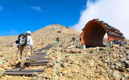 御嶽山の長野県側を登る火山防災訓練の関係者＝２６日午前