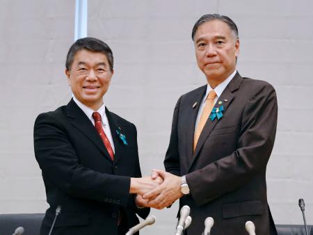 全国知事会会長の村井嘉浩宮城県知事（左）と握手する、新会長に選ばれた阿部守一長野県知事＝２６日午後、東京都千代田区
