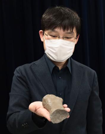 新属新種のセミクジラの一種と判明したクジラの化石を手にする札幌市博物館活動センターの田中嘉寛学芸員＝２６日午後、札幌市役所