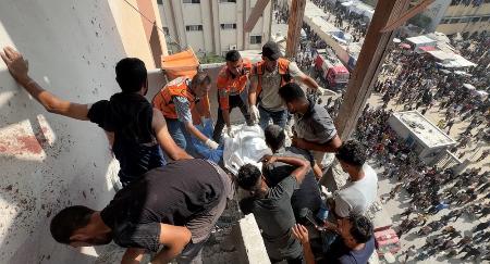 ガザ南部ハンユニスのナセル病院で、イスラエル軍の攻撃により死亡したカメラマンの遺体を運ぶ人々＝２５日（ロイター＝共同）