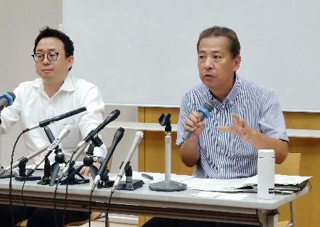 第１回口頭弁論を終え、支援者らに報告する兵庫県の丸尾牧県議（右）＝２７日午後、兵庫県尼崎市