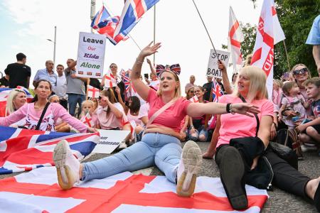 英南東部ハートフォードシャーのホテル前で、難民申請者の立ち退きを求めるデモの参加者＝２２日（共同）