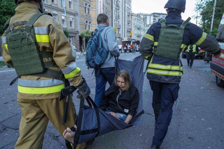 ロシアによる攻撃で負傷した女性を運ぶ救助隊員＝２８日、ウクライナ・キーウ近郊（ＡＰ＝共同）