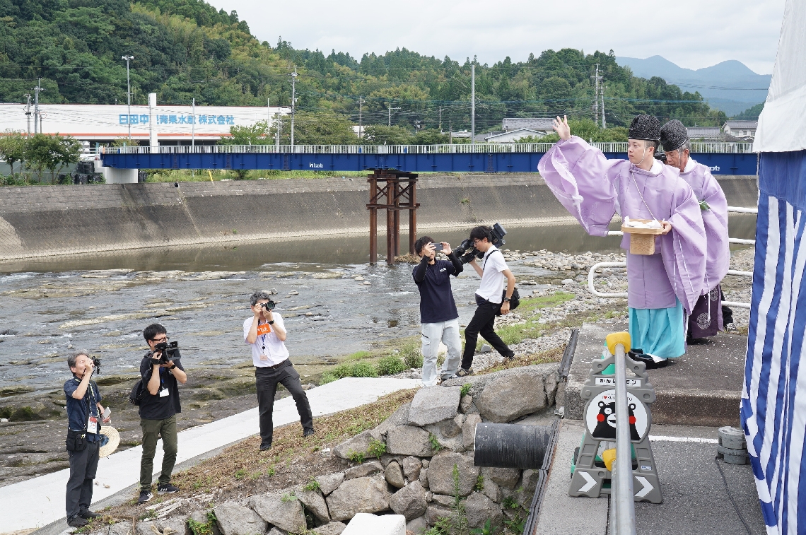 三郎丸橋の復旧工事現場で安全を祈願する神職