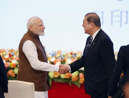 日印経済フォーラムで握手する石破首相（右）とインドのモディ首相＝２９日午後、東京都千代田区
