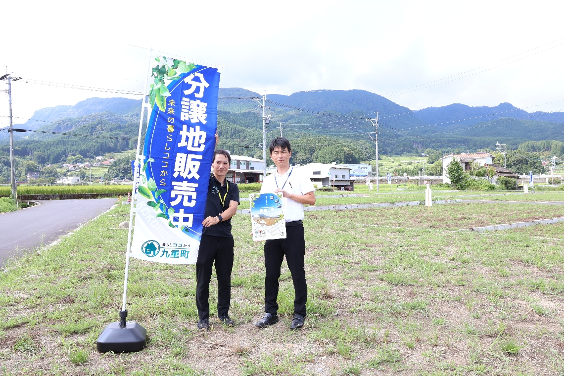 「玖珠盆地の雄大な眺めが広がる分譲地。ぜひ検討を」と呼びかける九重町職員＝九重町右田