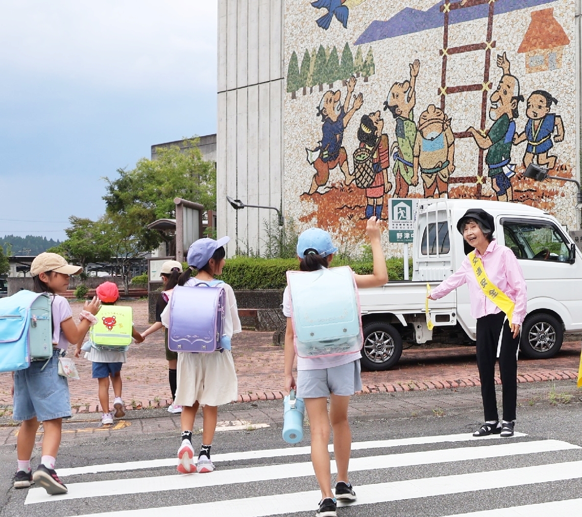 横断歩道の見守りをする吉四六おへま防犯パトロール隊の渡辺麻里子さん＝臼杵市野津町野津市