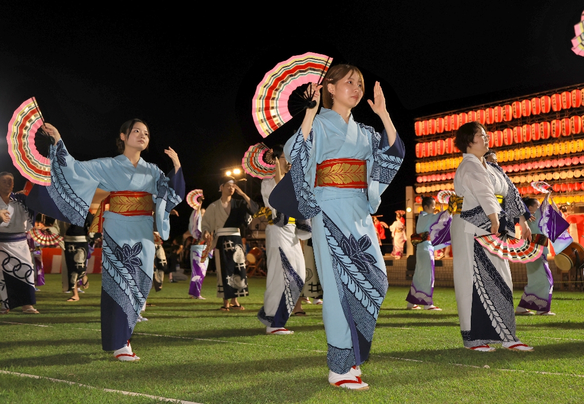 優雅な扇子踊りを披露する参加者たち＝３０日夜、津久見市のつくみん公園