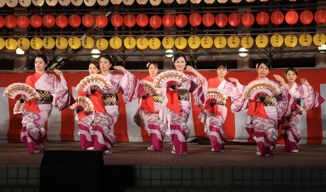 舞台上で優雅に踊る扇子踊り娘