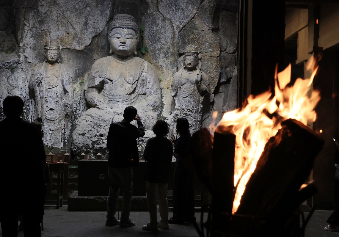 かがり火に照らされた石仏