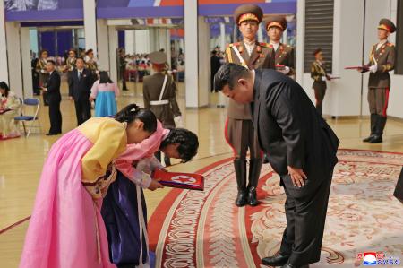 戦死した北朝鮮兵の遺族と面会する金正恩朝鮮労働党総書記（手前右）＝２９日、平壌（朝鮮中央通信＝共同）