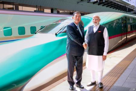 東北新幹線を背に握手する石破首相（左）とインドのモディ首相＝３０日、ＪＲ東京駅（内閣広報室提供）