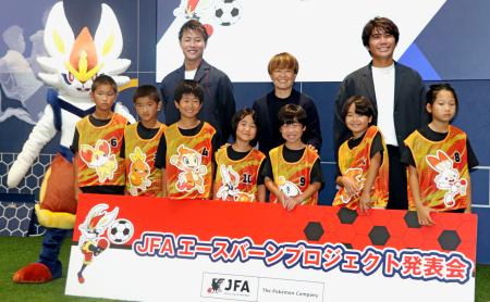 ポケモンがデザインされたビブスを着た子どもたちと記念撮影するサッカー元女子日本代表の宮間あやさん（後列中央）ら＝３１日、東京都文京区