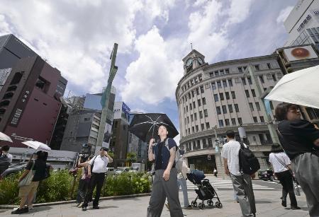 日傘を手に東京・銀座を歩く人たち＝７月