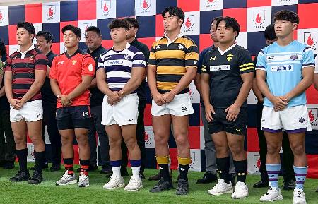 ラグビーの関東大学リーグ開幕に向けた記者会見で、胸にスポンサーのロゴを入れたジャージーを披露した明大の平主将（前列左から３人目）ら＝１日、東京都港区