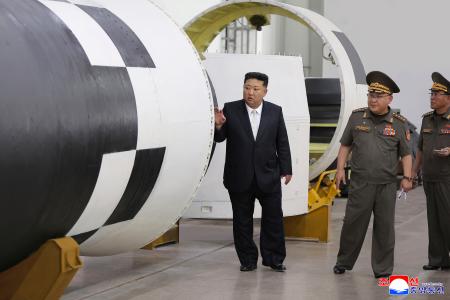 ミサイル総局傘下の化学材料総合研究院の研究所を訪れた北朝鮮の金正恩朝鮮労働党総書記（左）＝１日（朝鮮中央通信＝共同）