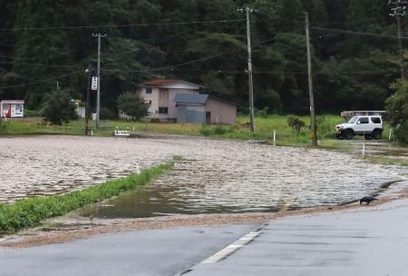 大雨の影響で冠水した秋田市内の道路＝２日午後２時４５分