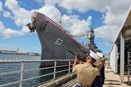 日本が降伏文書を調印した戦艦ミズーリのそばで、礼砲を撃つ米海兵隊員ら＝２日、米ハワイ州真珠湾の埠頭（ロイター＝共同）