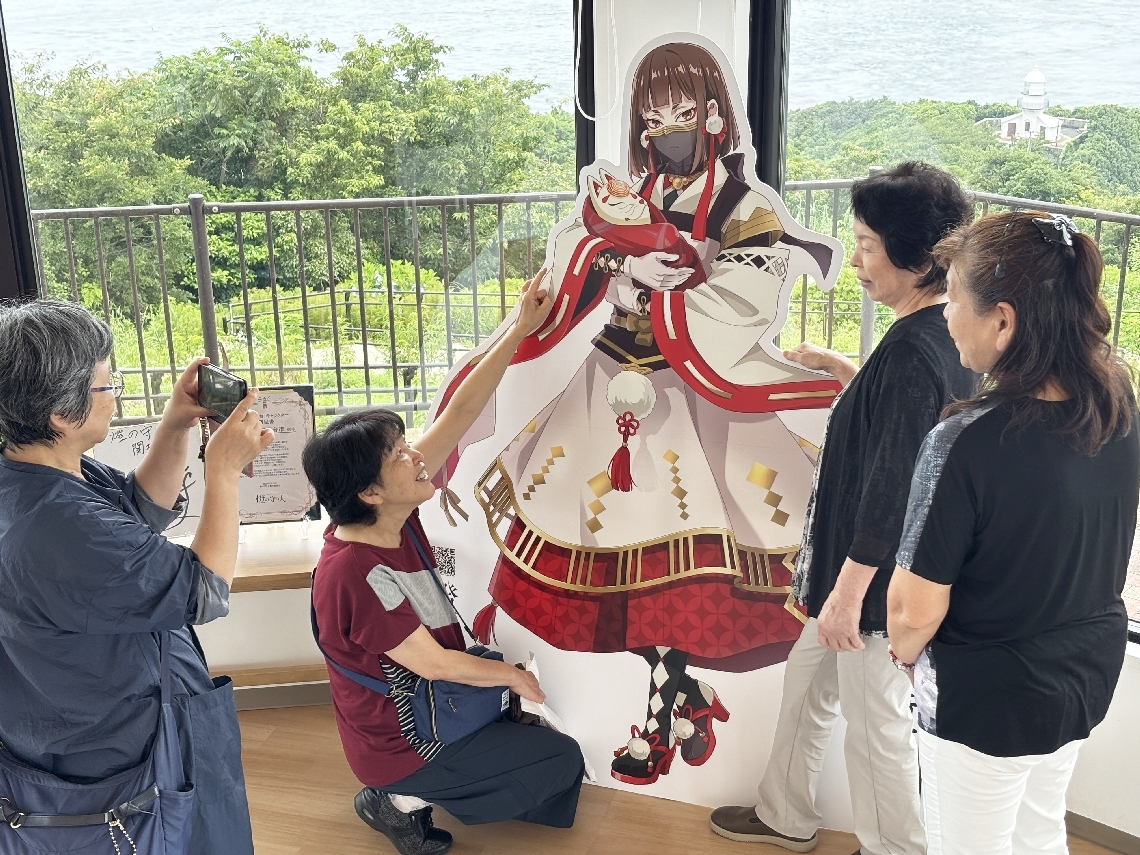 関埼灯台のキャラクターを見る人たち＝大分市佐賀関