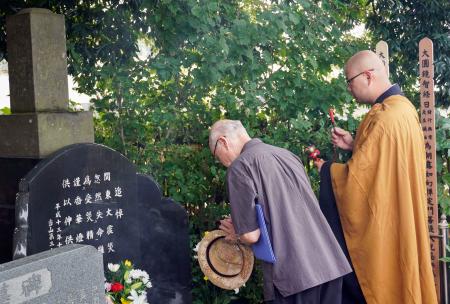 関東大震災時に虐殺された姜大興さんの墓前で手を合わせる人＝４日午後、さいたま市見沼区