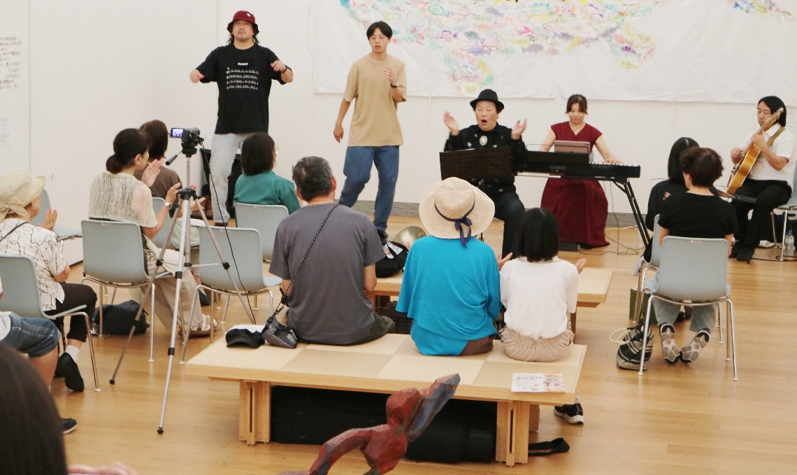 全員で「上を向いて歩こう」を合唱する「やさしくなる絵本～大分と神戸のアーティスト響宴」の様子